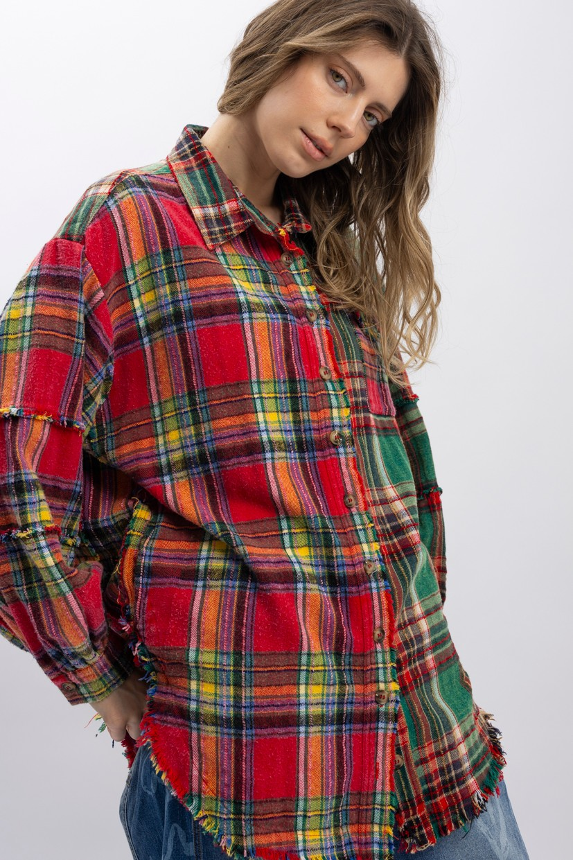 Model wearing a multicolor plaid button-up shirt with long sleeves, contrasting plaid panels, and a frayed curved hem.