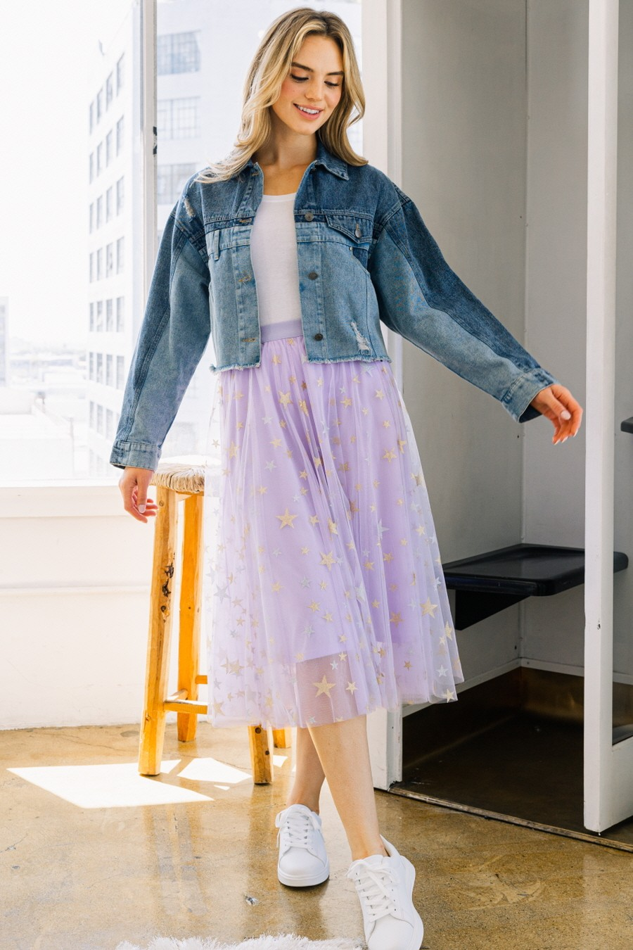 Model wearing lavender star-patterned tulle midi skirt with denim jacket and sneakers