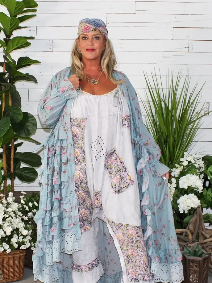 Pale-blue floral open-front duster with cascading ruffles, long sleeves, and eyelet hem, styled over white patchwork separates.