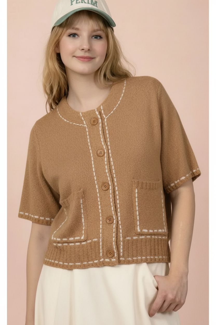 Brown contrast-stitch knit top styled with a cream skirt