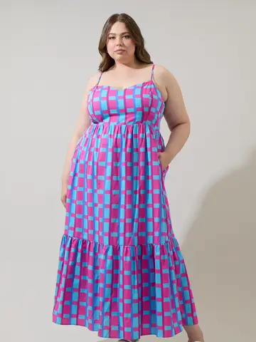 Model wearing a pink and blue checkered tiered maxi sundress with spaghetti straps and a ruffled hem