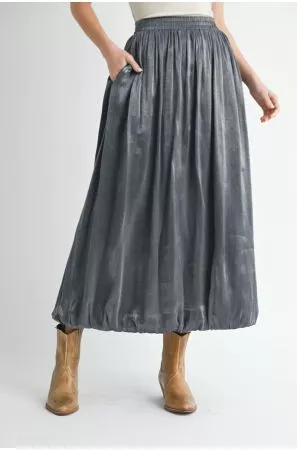 Charcoal-gray maxi skirt with gathered waist, side pockets, and rounded hem, styled with tan boots.