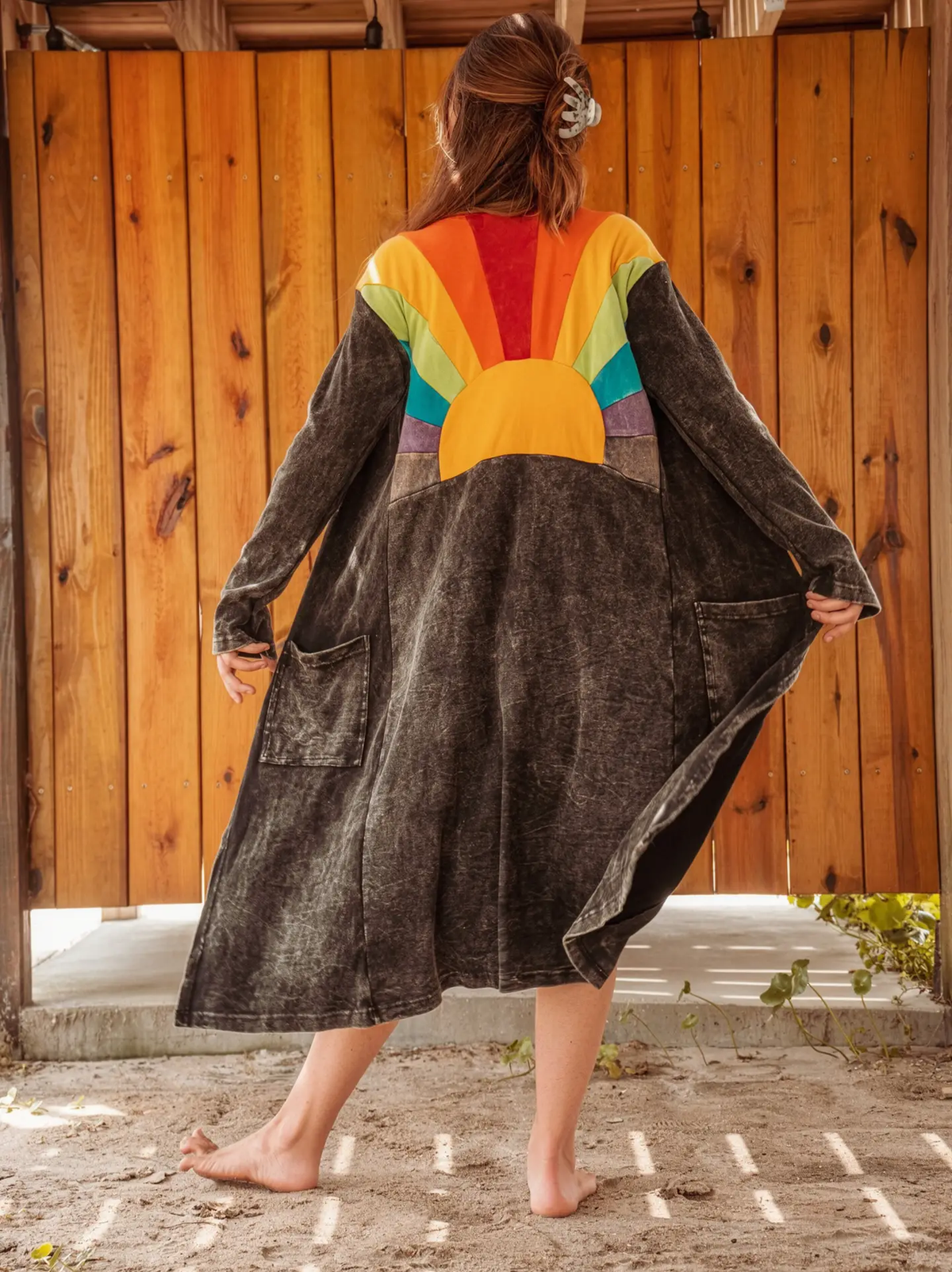 Dark washed longline duster with rainbow sunburst design across the back
