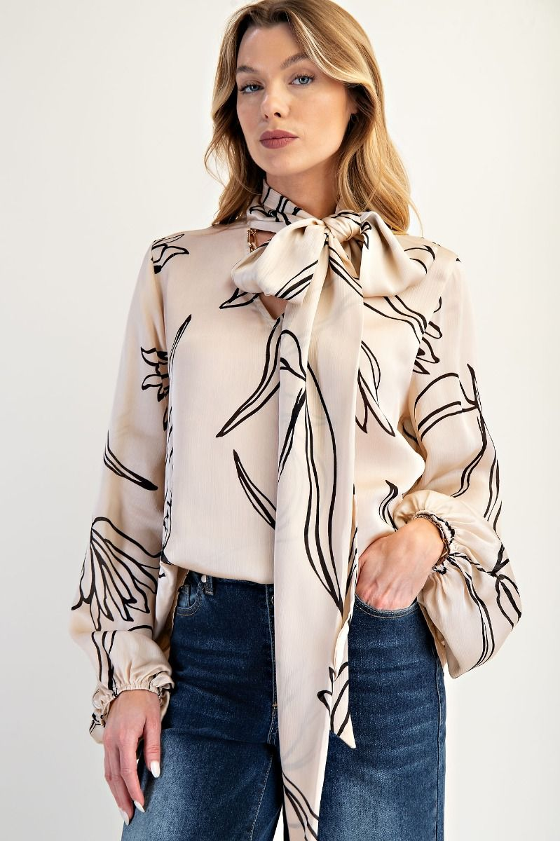 Ivory blouse with black floral linework, oversized bow neckline, and gathered sleeves