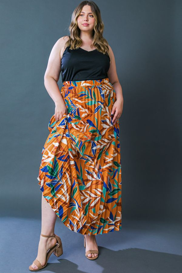 Model wearing the matching orange botanical-print tiered maxi skirt with a black sleeveless top