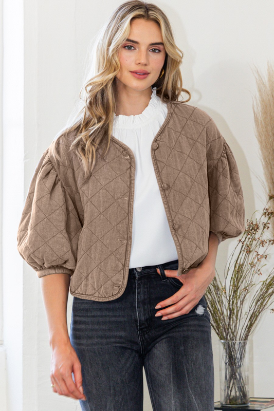 Taupe diamond-quilted jacket with puff sleeves and a button front, styled over a white top.