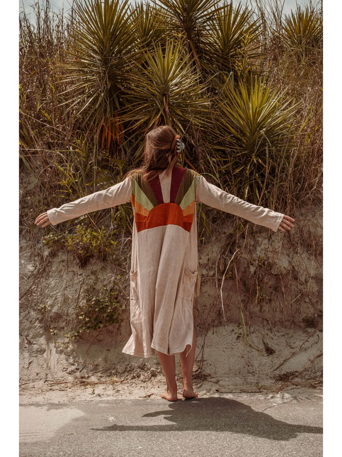 Cream longline duster with earth-tone sunburst design across the back