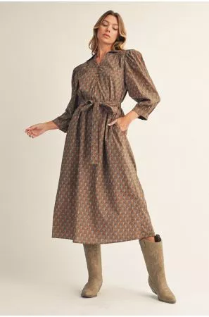 Model wearing a brown printed long-sleeve midi dress with a matching waist tie and taupe knee-high boots.