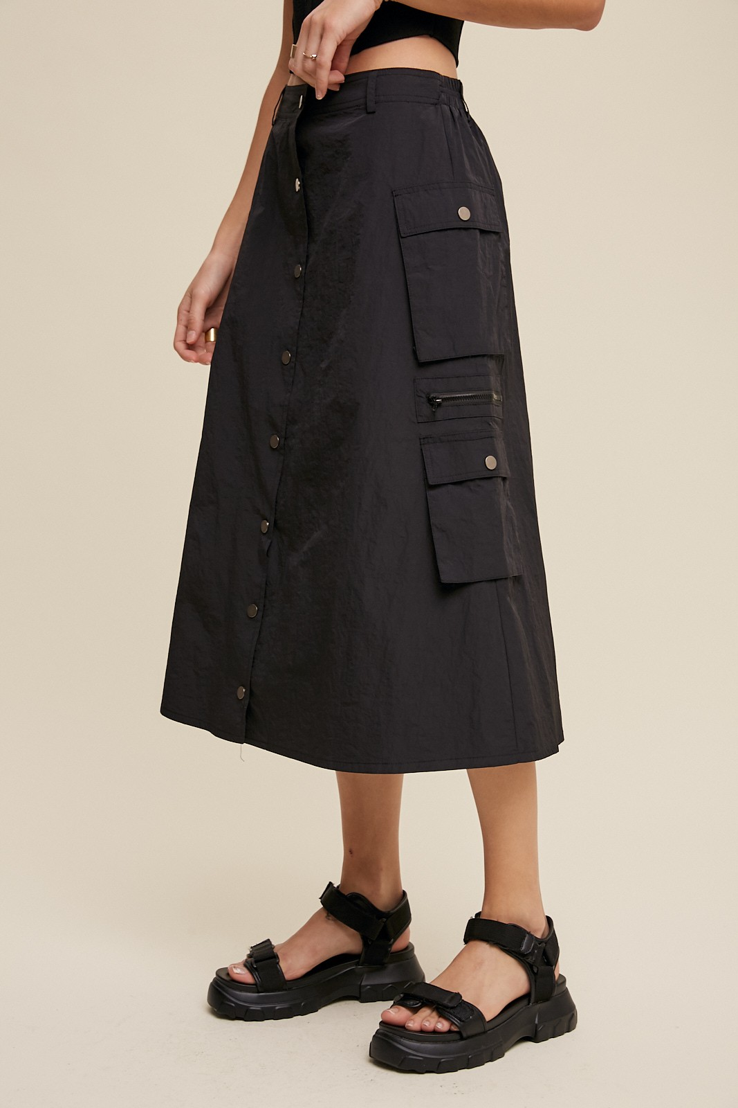 Black button-front cargo midi skirt with flap pockets and zipper details