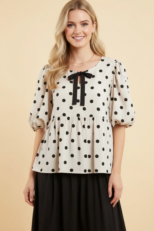 Ivory polka-dot bow-front top styled with a black skirt
