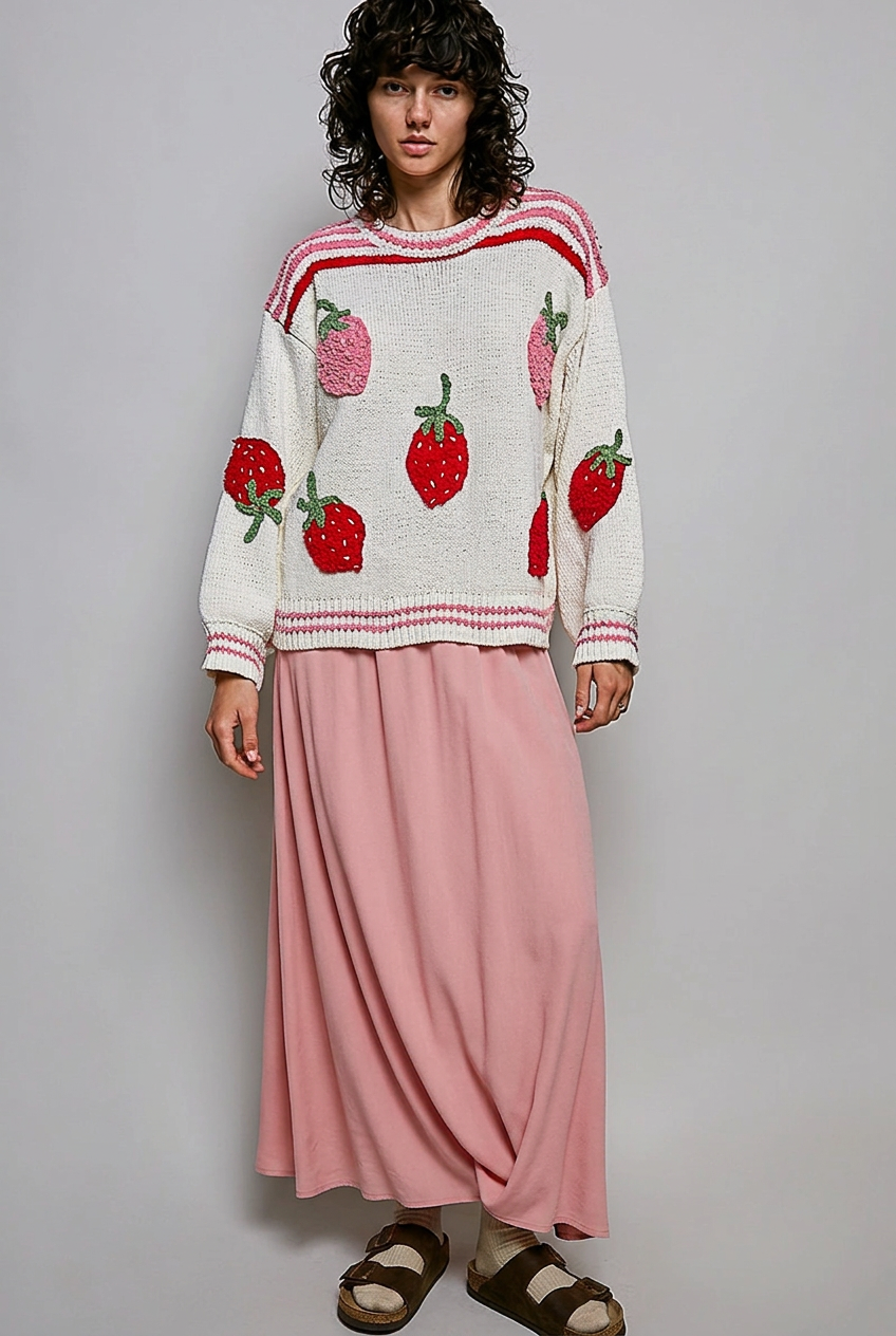 Model wearing a strawberry sweater with a long pink skirt